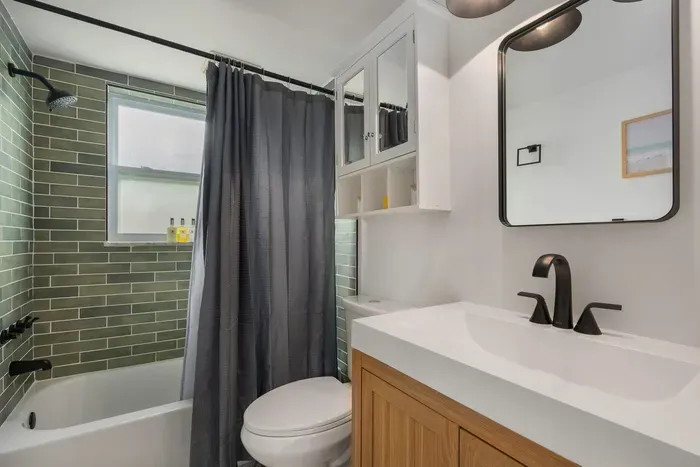 Fresh, modern bathroom with sleek vanity, stylish fixtures, and a tiled tub-shower combo. Clean, bright, and thoughtfully designed, it’s the perfect space to refresh and unwind in comfort.