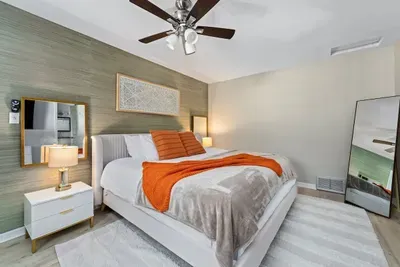 Main bedroom with a King bed, ceiling fan, and TV