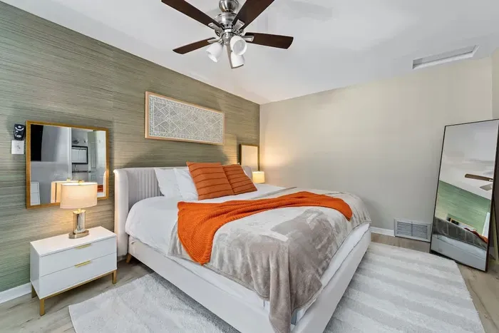 Main bedroom with a King bed, ceiling fan, and TV