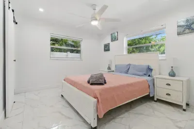 Relax in this comfortable bedroom featuring a double-sized bed, perfect for a restful night’s sleep. The room is filled with natural light from two large windows, creating a bright and airy ambiance.