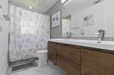 This spacious and inviting bathroom offers both comfort and convenience, featuring a large double-sized sink perfect for getting ready together.