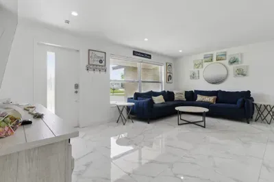The spacious layout features a cozy seating area, a stylish entrance, and a wide window that fills the space with natural light. Whether you're relaxing indoors or enjoying the view, this inviting space sets the perfect tone for your stay.