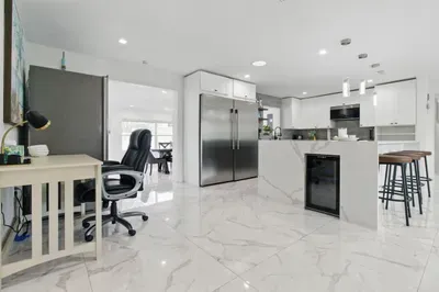 This well-equipped kitchen features a full-size refrigerator, perfect for storing groceries during longer stays, along with plenty of counter space for meal prep. A convenient side workspace offers extra room for working remotely.