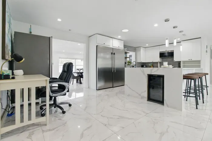 This well-equipped kitchen features a full-size refrigerator, perfect for storing groceries during longer stays, along with plenty of counter space for meal prep. A convenient side workspace offers extra room for working remotely.