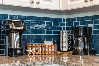 Start your morning right at this coastal coffee nook, featuring both drip and single-serve makers, ocean-blue tile, and a touch of beachy charm. Perfect for brewing your favorite cup before a relaxing day by the shore.