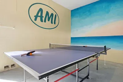 Featuring a full-size ping pong table set against a vibrant beach mural and bold AMI wall art. Perfect for friendly matches, rainy-day entertainment, or evening tournaments that bring everyone together.