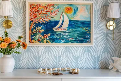 Vibrant coastal artwork and chic lighting create a cheerful focal point in this beach-inspired space. Bright colors, nautical charm, and elegant details bring warmth and personality to the room’s relaxing seaside vibe.