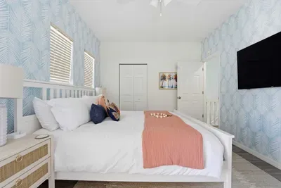 A plush king bed, soft coastal tones, patterned accent wall, and flat-screen TV for cozy nights in. Light-filled and spacious, this calming haven is perfect for unwinding after a day of fun and sun.