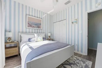 Featuring a plush bed with soft layered linens, warm wood nightstands, and gentle natural light. This bright, airy space offers a peaceful escape for restful nights and refreshed mornings.