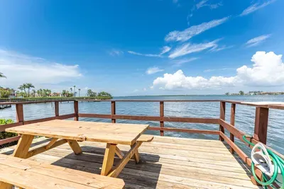 Peaceful waterfront deck with a picnic table overlooking calm bay waters. Perfect for morning coffee, sunset views, or a quiet meal surrounded by stunning coastal scenery.