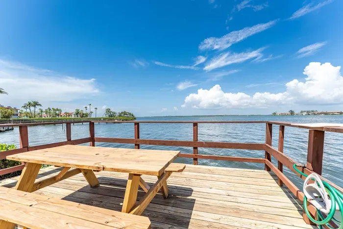 Peaceful waterfront deck with a picnic table overlooking calm bay waters. Perfect for morning coffee, sunset views, or a quiet meal surrounded by stunning coastal scenery.