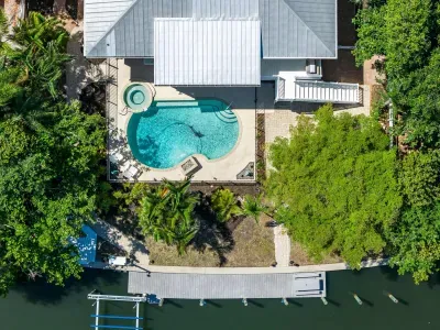 Bird’s-eye view of your private waterfront oasis. Enjoy a sparkling pool, relaxing spa, lush tropical surroundings, and private dock access — the ultimate Florida retreat for unforgettable island vacations and waterfront adventures!