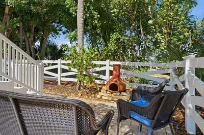Cozy tropical patio seating area. Relax outdoors surrounded by lush greenery and peaceful island vibes — the perfect spot for morning coffee, evening chats, or unwinding after a fun beach day!