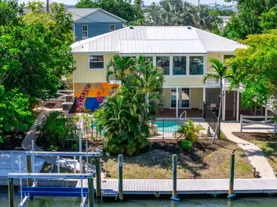 Beautiful waterfront retreat with a private dock, tropical pool oasis, and peaceful island vibes.