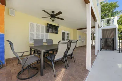 Covered outdoor dining with poolside views. Enjoy meals, morning coffee, or evening drinks in this relaxing shaded patio space just steps from the pool and beautiful tropical surroundings!