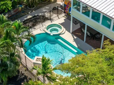 Aerial view of your private tropical oasis. Enjoy the sparkling pool, relaxing spa, and peaceful island setting surrounded by lush palms — the perfect retreat for unforgettable Florida vacation memories!