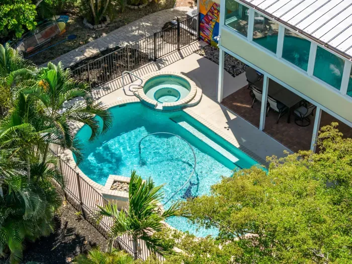 Aerial view of your private tropical oasis. Enjoy the sparkling pool, relaxing spa, and peaceful island setting surrounded by lush palms — the perfect retreat for unforgettable Florida vacation memories!