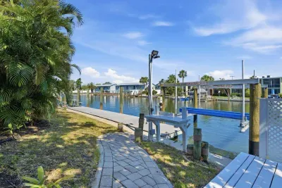 Peaceful waterfront pathway and private dock. Enjoy direct canal access, beautiful water views, and the perfect tropical setting for boating, fishing, or relaxing by the water during your Florida getaway!