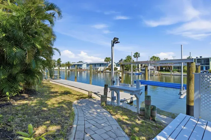 Peaceful waterfront pathway and private dock. Enjoy direct canal access, beautiful water views, and the perfect tropical setting for boating, fishing, or relaxing by the water during your Florida getaway!