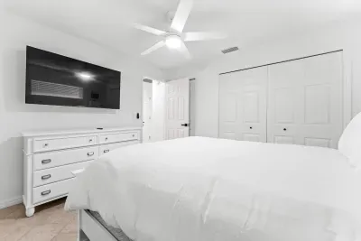 Relax in a peaceful space featuring a cozy bed, TV, and plenty of storage — the perfect retreat to unwind after a fun day at the beach.