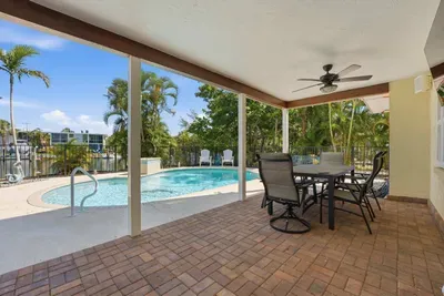 Relax poolside in this beautiful covered outdoor patio. Enjoy waterfront views, shaded seating, and the perfect space for outdoor dining, morning coffee, or unwinding after a fun beach day!