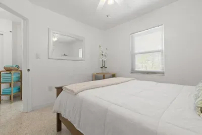 Bedroom looking into hallway that leads to bathroom and main living area.