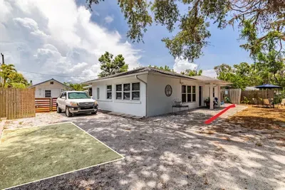 Exterior view of the home with designated parking area (green square). The red arrow takes you around to the side entrance of the home where the guest suite is located.
