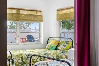 Wake up to sunshine and swaying palms in this vibrant bedroom featuring twin tropical-print full-size beds.