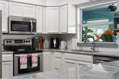 This pristine kitchen is a tropical dream come true! Cook up your favorite meals with ease thanks to modern stainless steel appliances, including a smooth-top stove, microwave, and dishwasher.