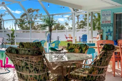 Dine in paradise! This charming glass-top patio set surrounded by lush tropical cushions offers the perfect setting for sun-soaked breakfasts or candlelit dinners.