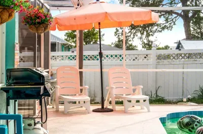 Soak up the Florida sunshine on these cozy poolside loungers, shaded by a vibrant umbrella for comfort and style. Fire up the gas grill for a backyard cookout while you unwind just steps from the pool.