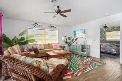 Step into a tropical oasis where vibrant colors, rattan furniture, and beachy décor set the tone for a relaxing getaway. Kick back, watch your favorite show on the smart TV, or simply unwind in paradise—just steps away from the bedroom retreat.