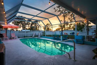 Welcome to your evening escape! Enjoy a peaceful swim or sip cocktails by the pool as the sun sets in this beautifully screened-in private pool area.