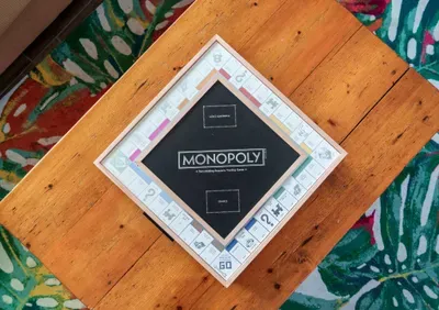 Unwind with a cozy game night around our rustic wooden coffee table, featuring classic favorites like Monopoly.