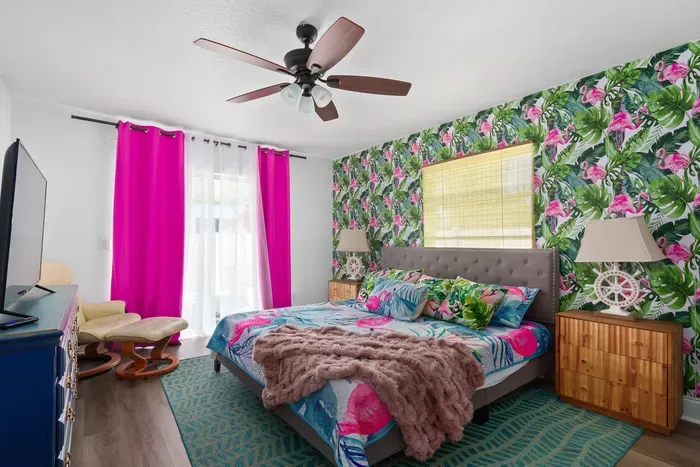 Drift off in paradise in this bold, island-inspired bedroom! Bursting with color and character, the space features a plush king-sized bed, eye-catching tropical wallpaper, and luxurious linens for ultimate comfort.