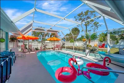 Soak up the sun in this vibrant, screened-in oasis! Heated pool, fun floats, colorful umbrellas, and total privacy perfect for your next getaway.