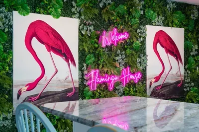 Step into your tropical escape with this unforgettable welcome wall! Featuring lush greenery, twin vibrant flamingo prints and a glowing pink neon sign that sets the tone for your stay this signature spot is perfect for photo ops and first impression