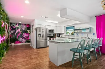 Whip up your favorite meals in this fully equipped, tropical-themed kitchen! Featuring stainless steel appliances, granite countertops, and a large island with seating for four, this space is both functional and fun.