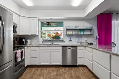 Whip up island-inspired meals in this spacious, fully equipped kitchen featuring stainless steel appliances, sleek white cabinetry, and ample counter space for cooking or entertaining.