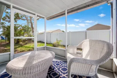 Start your day with coffee or unwind in the evening in this charming screened-in patio.