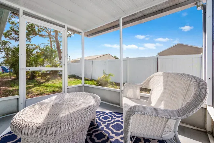 Start your day with coffee or unwind in the evening in this charming screened-in patio.