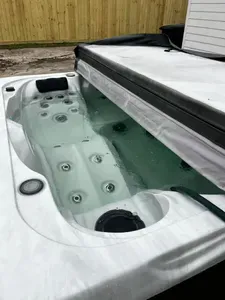 Welcome to your perfect getaway! Enjoy a private outdoor space featuring a relaxing hot tub surrounded by lush green turf, perfect for soaking after a day of adventures.