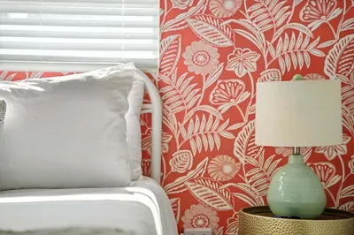 Wake up in style with a vibrant coral floral accent wall, crisp white bedding, and a soft glow from a chic mint-green lamp. This cozy corner blends comfort and charm, creating the perfect retreat for restful nights.
