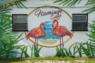 Capture the vibrant spirit of Flamingo Cay with this stunning mural of two flamingos by the sea, framed by lush tropical leaves. A perfect Instagram-worthy spot that sets the tone for your colorful coastal getaway.