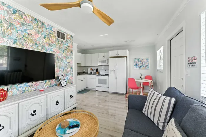 Open-concept living with a splash of color! Relax on the cozy sofa, enjoy the vibrant accent wall, and cook in the fully equipped kitchen. Bright dining nook and modern amenities make this space perfect for comfort and style