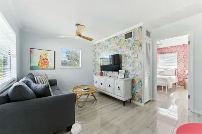 Bright & modern oasis with vibrant accent wall, sleek tile floors, and cozy lounge area. Enjoy unique art, a stylish bedroom, and natural light throughout—perfect for relaxing after exploring the city!