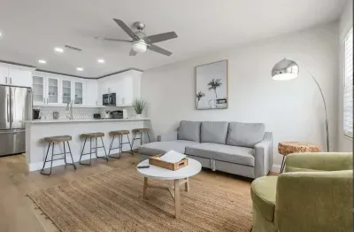 Bright and inviting living space with modern furnishings, cozy sofa, and stylish décor. Open layout flows into a sleek kitchen and breakfast bar—ideal for relaxing, socializing, or unwinding after a day of adventure.