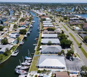 Aerial view of a peaceful waterfront neighborhood lined with charming homes. Enjoy easy canal access for scenic strolls, all just minutes from beaches, dining, and coastal attractions.