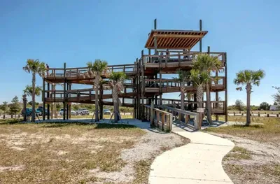 Enjoy stunning coastal views from this scenic wooden observation deck surrounded by palm trees. Perfect for sunset watching, nature photos, or a peaceful stroll, this spot captures the laid-back charm of the nearby beach area.