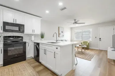 Bright open kitchen with modern appliances, sleek countertops, and cozy living area views. Perfect for cooking, dining, and relaxing in a stylish, welcoming space filled with natural light.